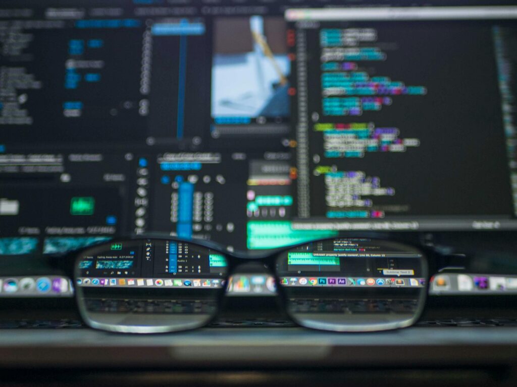 Photo by Kevin Ku: https://www.pexels.com/photo/data-codes-through-eyeglasses-577585/ Glasses over dark mode computer screen code background